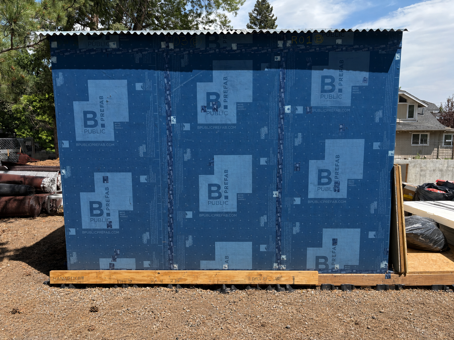 Back wall of shed showing full WRB wrap and corrugated shed roof